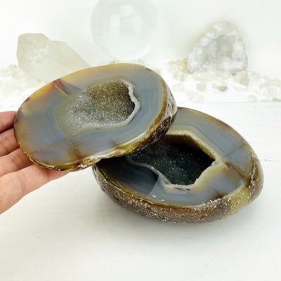 Agate geode box open displaying the pattern and druzy, one half of the geode is in a hand.
