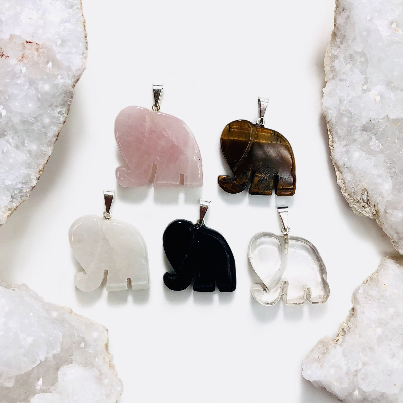 Elegant Gemstone Pendants Assorted next to a break geodes