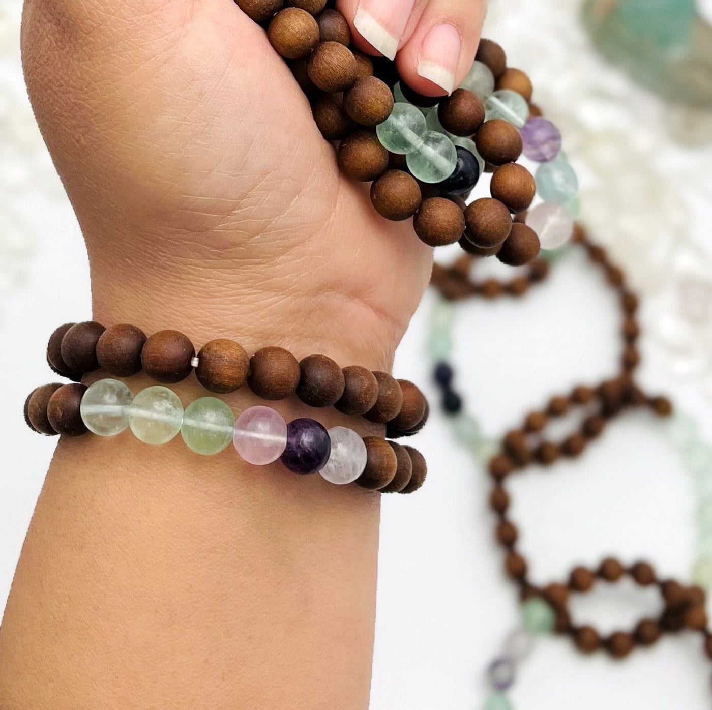 sandalwood bead bracelets with fluorite on wrist and in hand for size reference