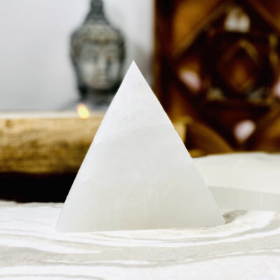 close up of one selenite triangle charging plate propped up  for details
