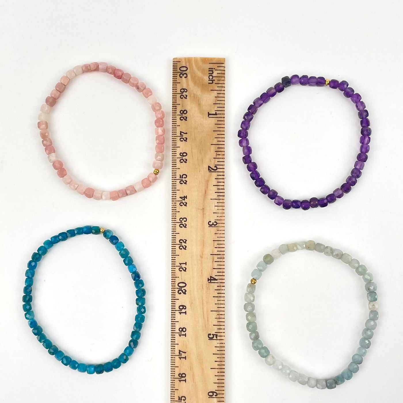 bracelets next to a ruler for size reference 