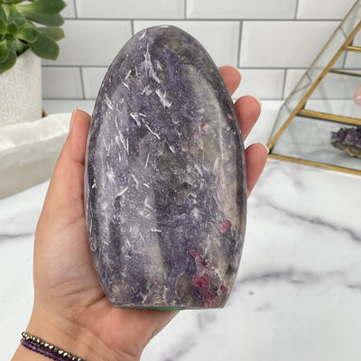 lepidolite cut base in hand for size reference 
