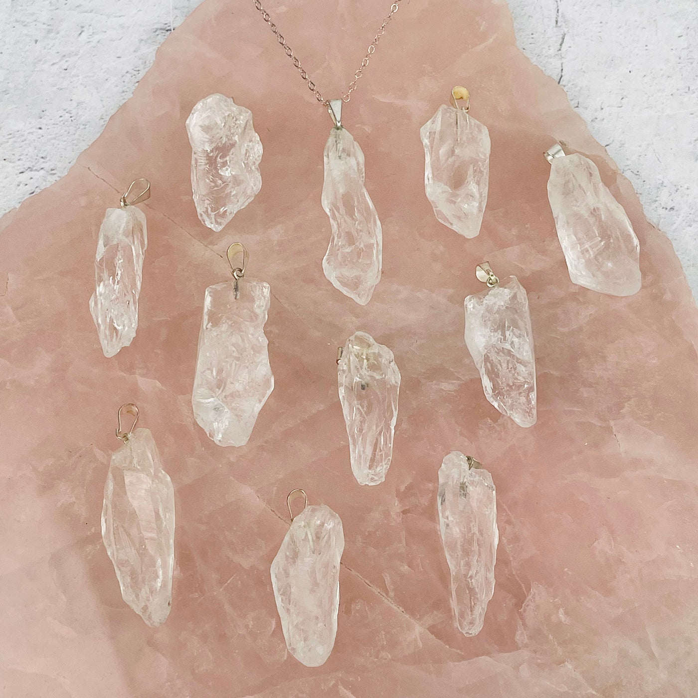 Crystal Quartz - Rough Stone Pendants with Silver Plated Bails displayed to show the differences in the sizes and shapes 