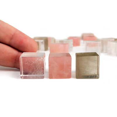6 Sided Gemstone Cubes next to finger tips for size reference
