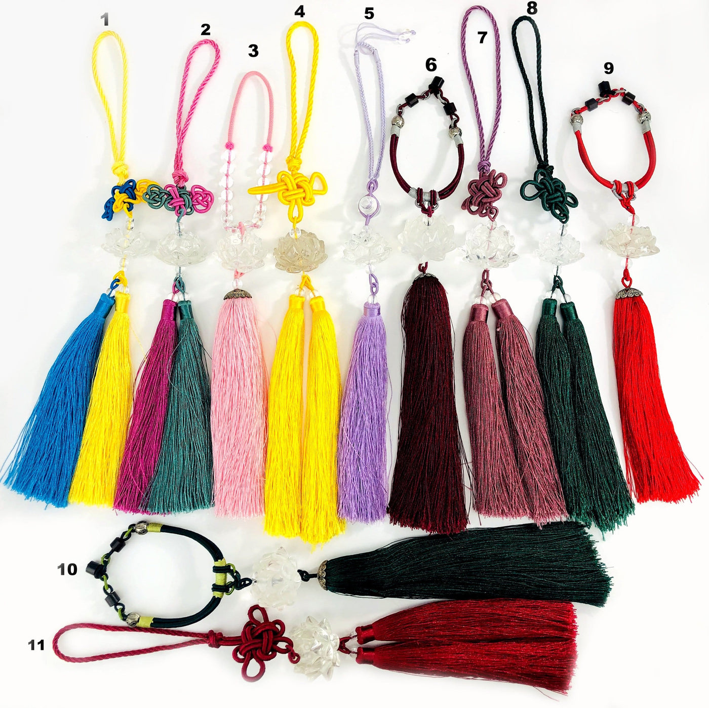11 different colored Lotus Flower Colored Tassels on white background