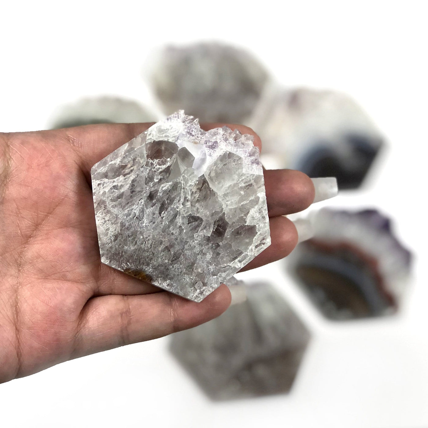 large amethyst slice displayed in hand for size reference