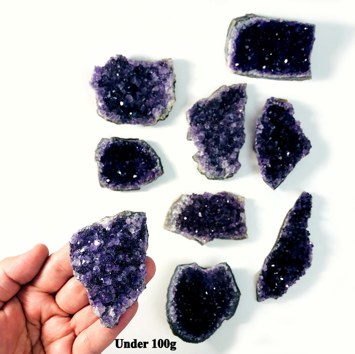 hand holding up amethyst cluster with others in the background