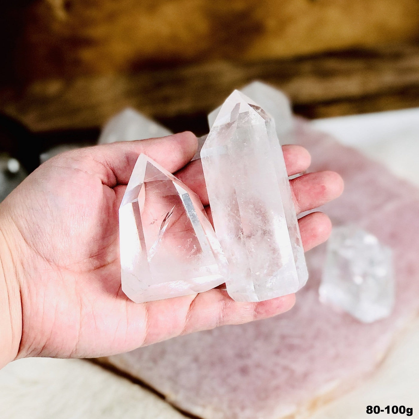 Crystal Quartz Polished Cut Base Points in a hand in the 80-100g size