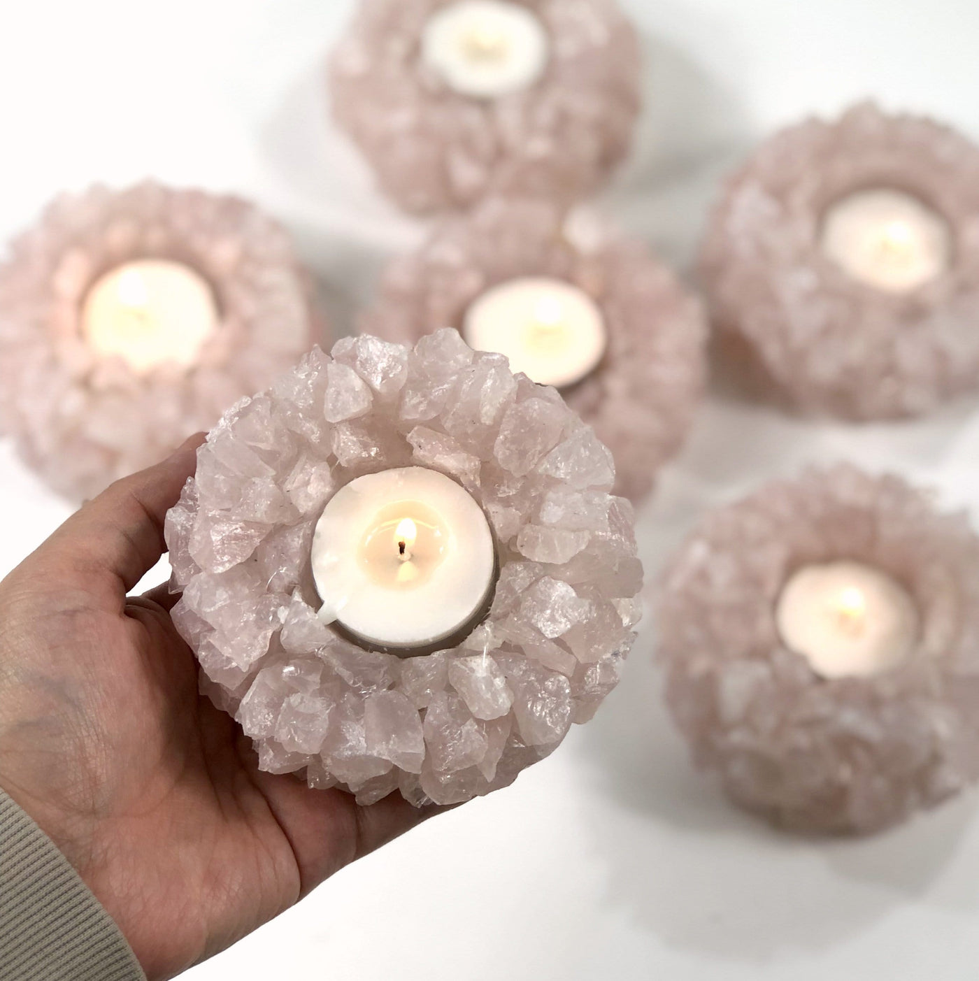 Hand holding up Rose Quartz Candle Holder with 5 others blurred in the background