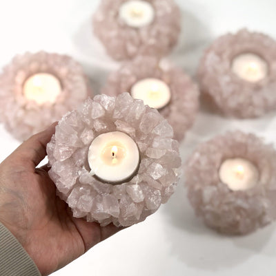 Hand holding up Rose Quartz Candle Holder with 5 others blurred in the background