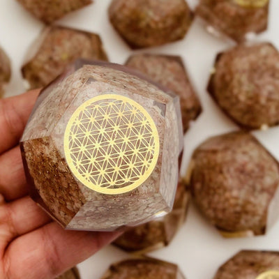 orgone sunstone with flower of life in a hand