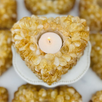 Citrine Tumbled stone Heart Candle Holder shown from overtop with a candle with others in the background