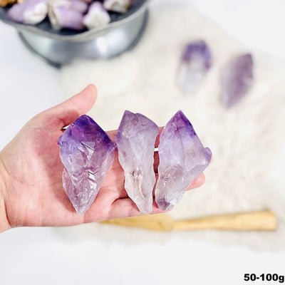 3 amethyst points in a hand
