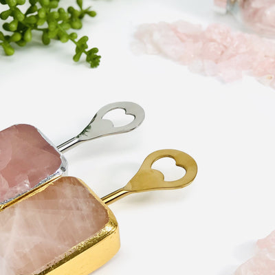 2 Rose Quartz Bottle Openers next to crystals and plants on white background