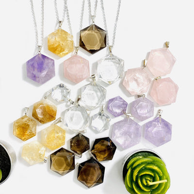 Hexagon Pendants with Silver Plated Bail laid out on a table shoing varying size