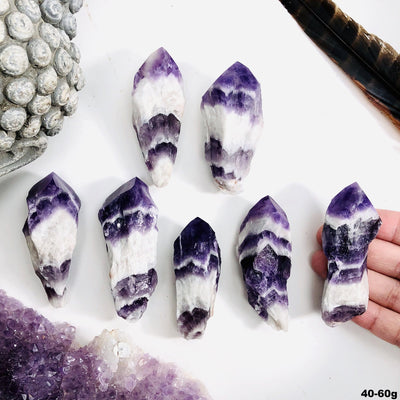 Seven amethyst chevron points are being displayed on a white back ground. for size 40 to 60 grams.