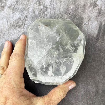 Crystal Quartz Polished Stone with a hand for size reference