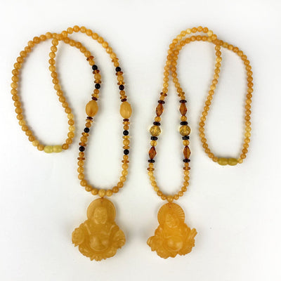 Amber Beaded Necklaces with Carved Buddha Pendants, laid out on display side by side