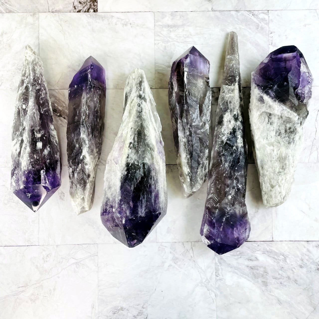 assorted elestial amethyst points on a marble background