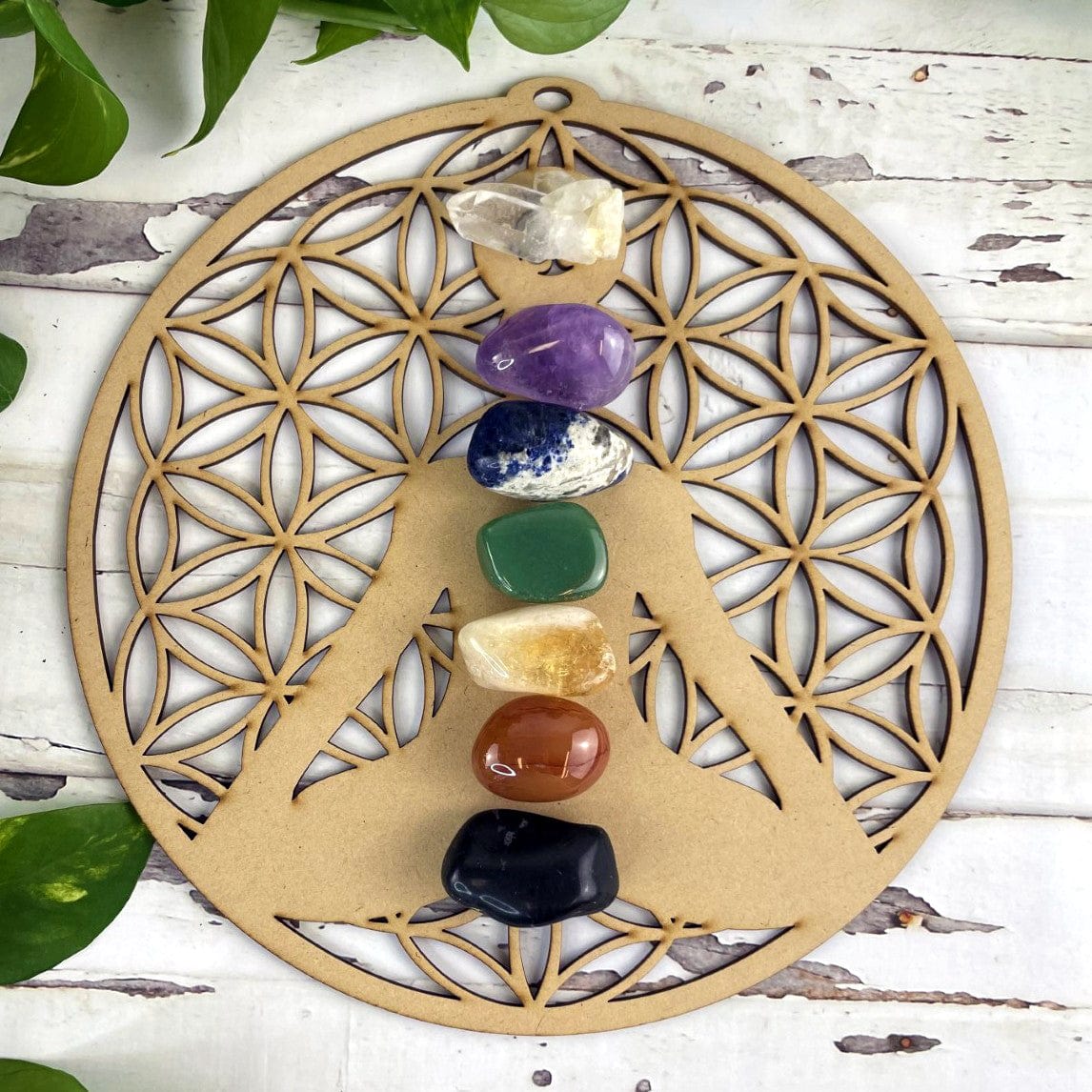 Wood Crystal Grid with Flower of Life Cut outs and a cut out of a person sitting in meditation pose. Chakra crystals were placed on the grid for the photo but not included with the product