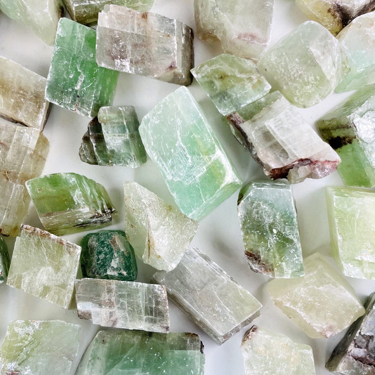 Green Calcite Stones assorted to show variation on a white background