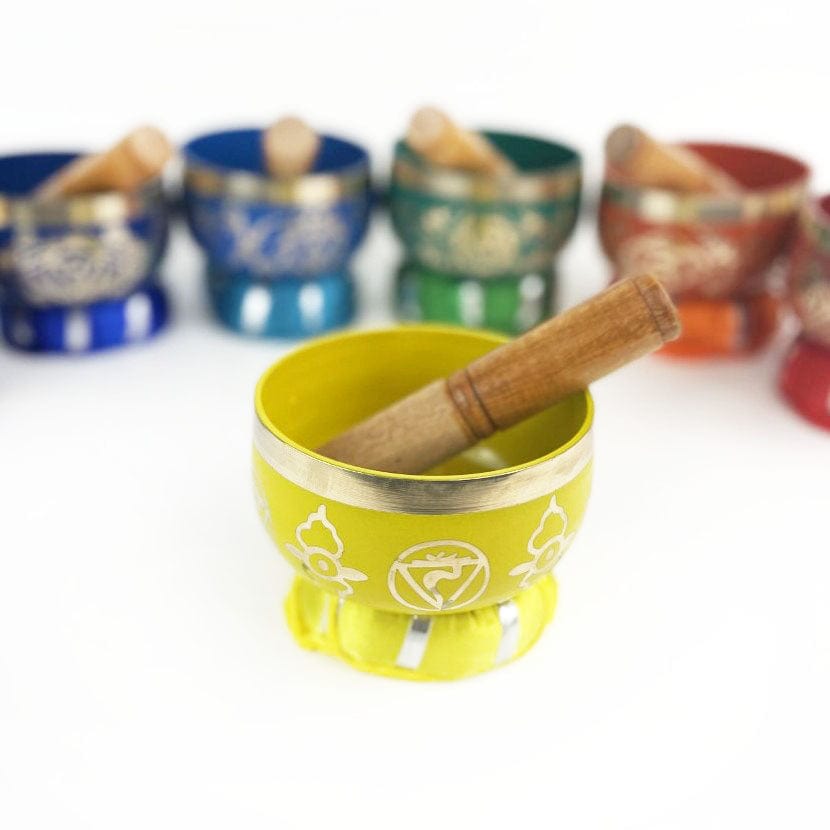 7 Chakra Colorful Singing Bowls, Pillows and Mallets with  close up on yellow one