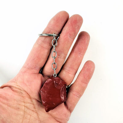 Red Jasper Polished Freeform Silver Toned Key Chain in a hand for size reference
