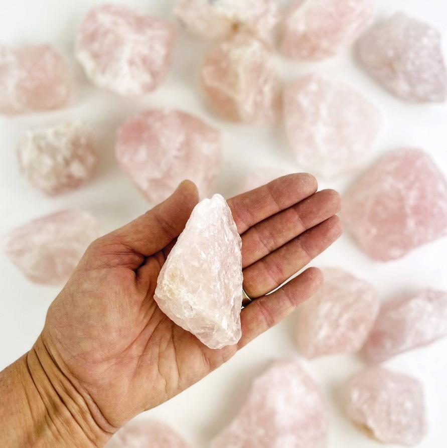 rose quartz rough stone in hand for size reference 
