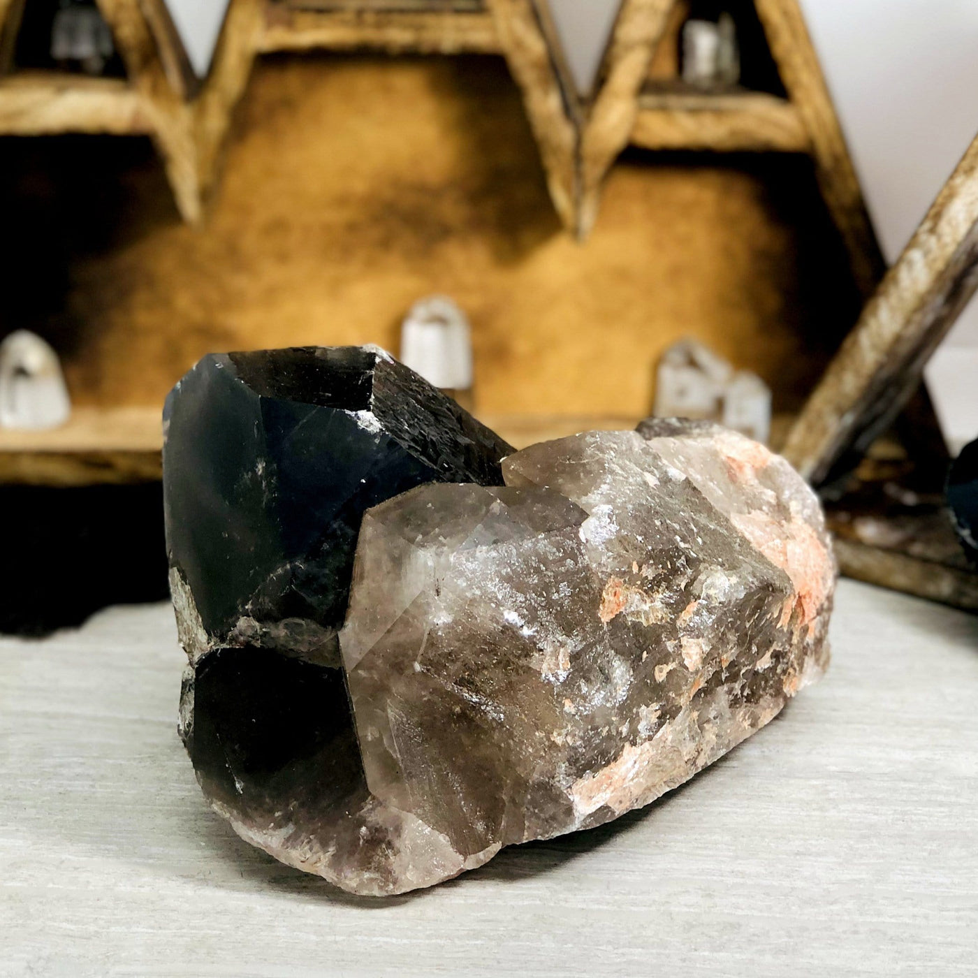 side view of smokey quartz semi-polished point on display for thickness