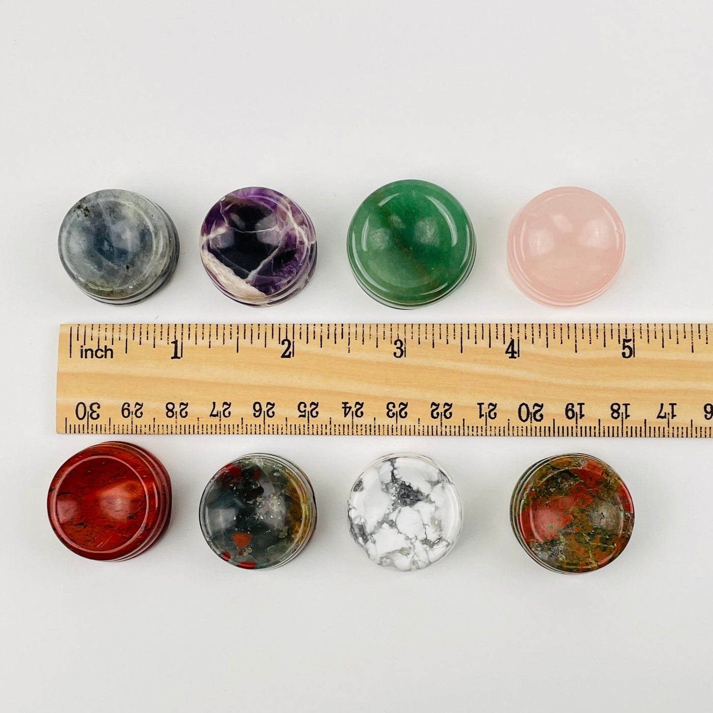 crystal sphere holders next to a ruler for size reference 