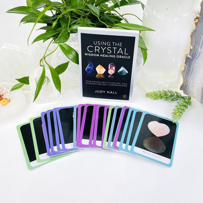 The Crystal Wisdom Healing Oracle by Judy Hall  with some cards displayed out for viewing.