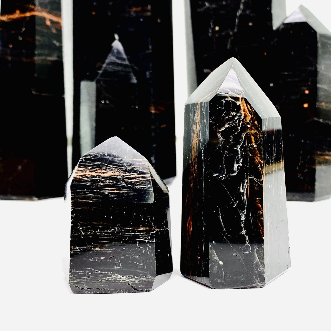 black tourmaline with red iron polished points on white background