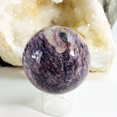 Charoite Polished Sphere with decorations in the background