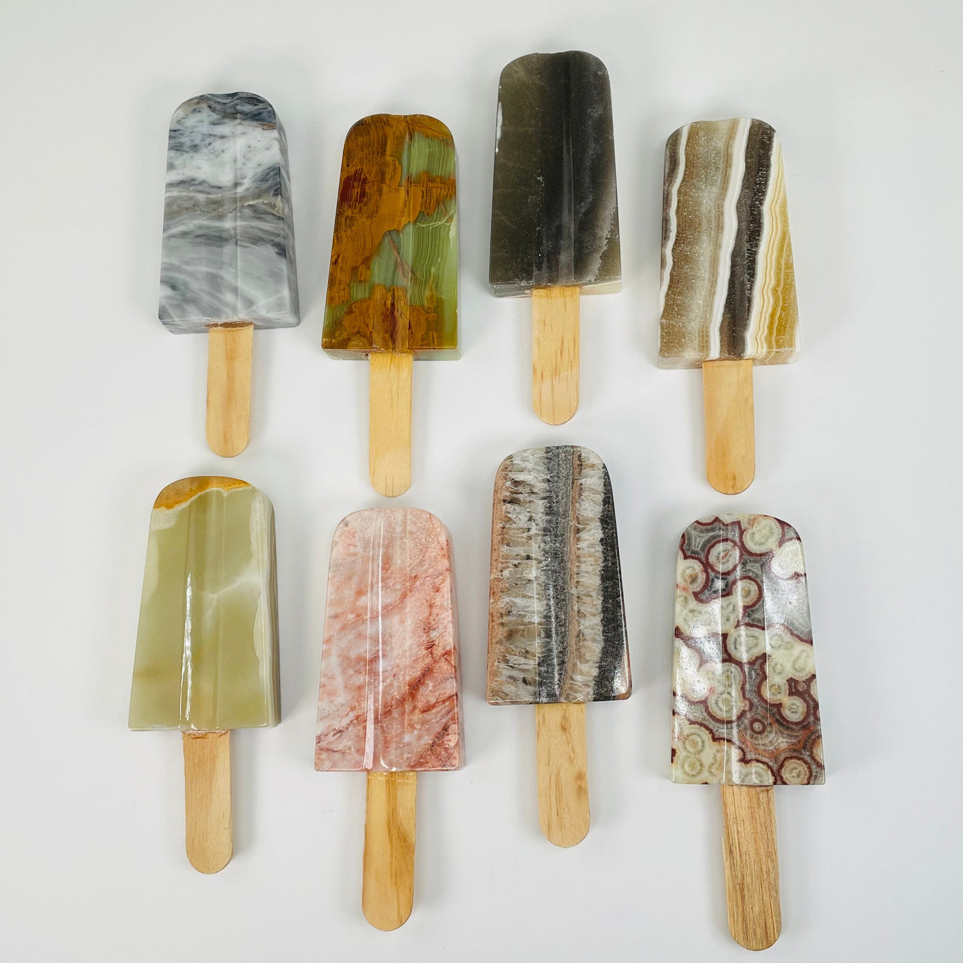 multiple onyx popsicle shaped stones displayed to show the differences in the colors available