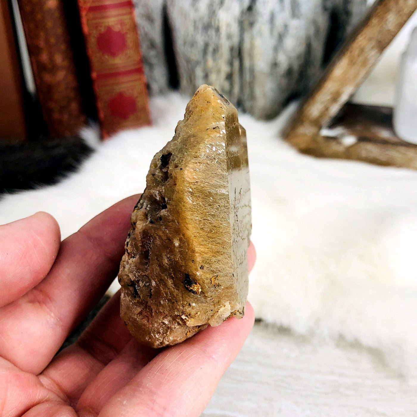 hand holding up Rutilated Natural Smokey Quartz Raw Formation showing side view