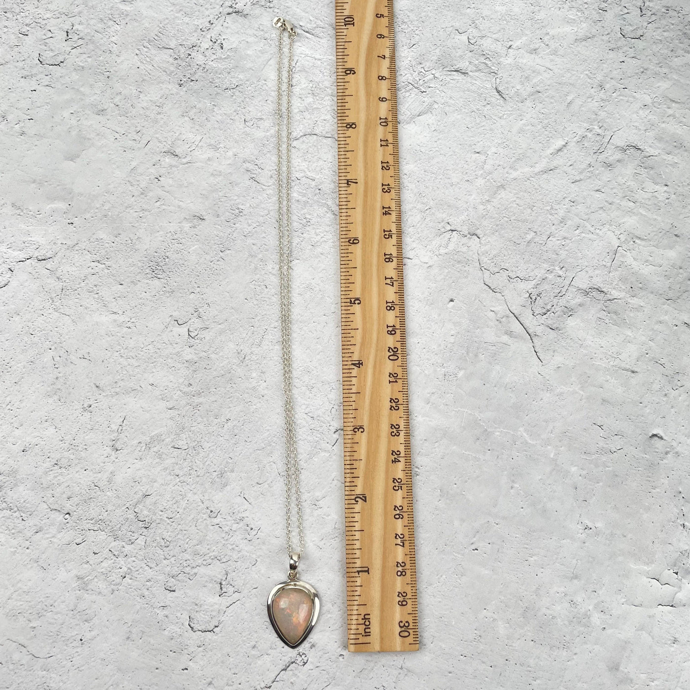 necklace next to a ruler for size reference. comes on an 18" long necklace 