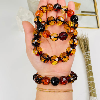 amber bracelets with faceted round beads in hand for size reference 