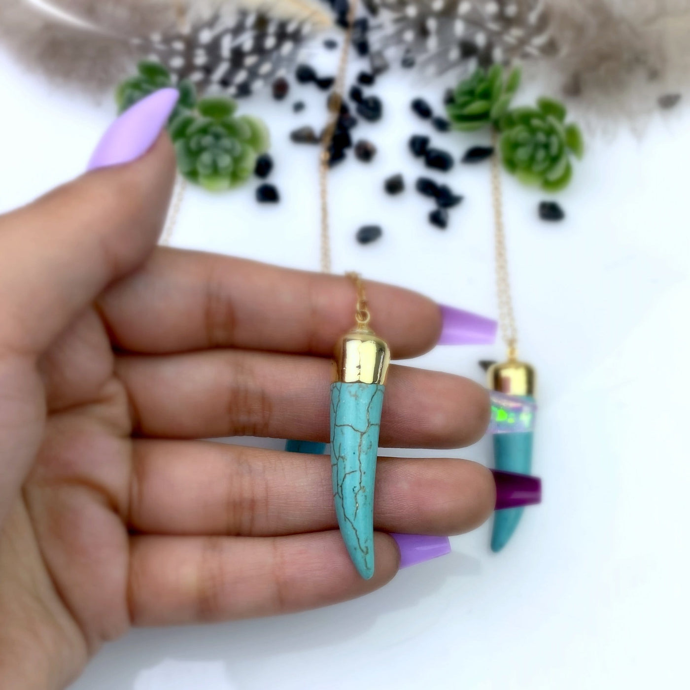 Turquoise Howlite Horn Necklace in hand for size reference