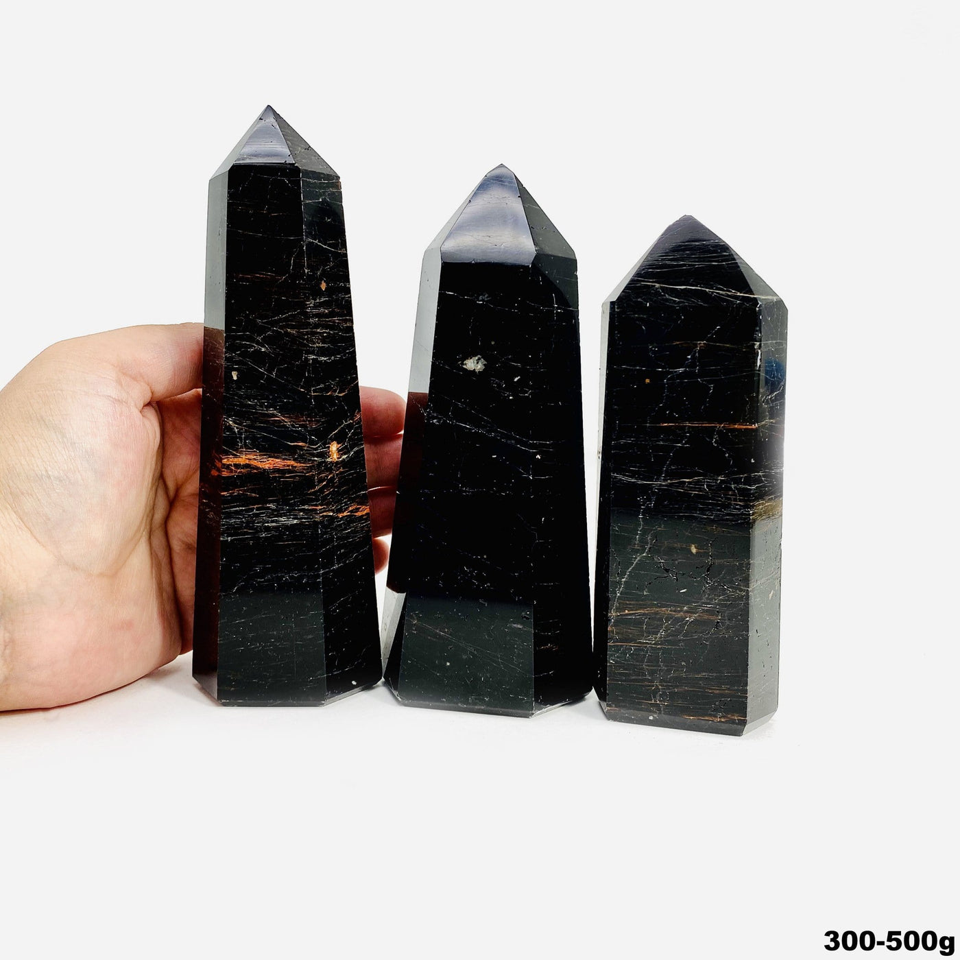 hand behind 300-500g black tourmaline with red iron polished points