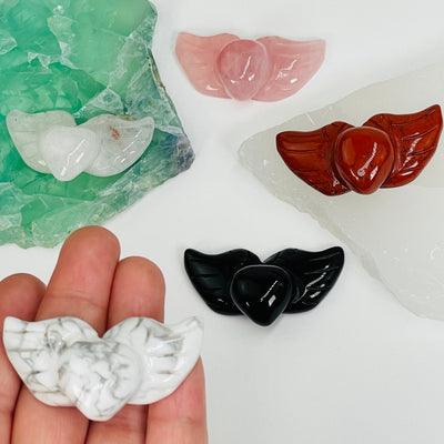 carved gemstone heart with wings in hand for size reference 