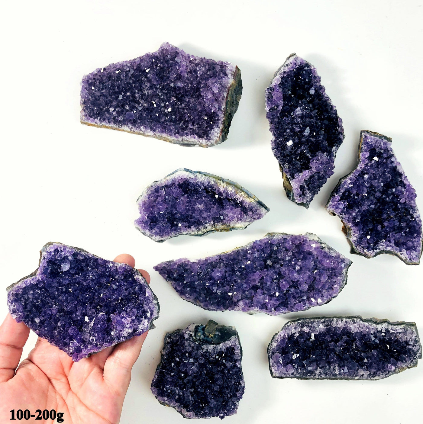 hand holding up amethyst cluster with others in the background