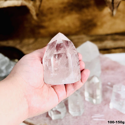 Crystal Quartz Polished Cut Base Point in a hand in the 100-150g size