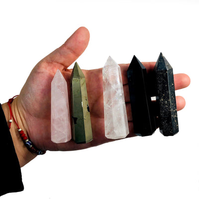 5 different colored Gemstone Pencil Polished Points displayed in palm of hand