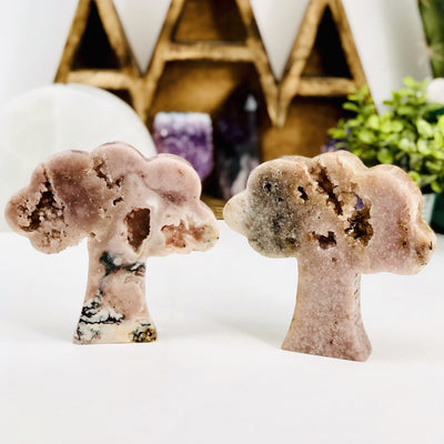 2 Pink Amethyst Cut Trees with decorations in the background