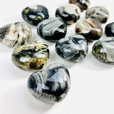 angled view of many silver leaf heart shaped stones for thickness