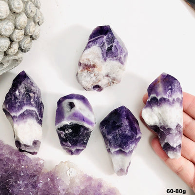 Five amethyst chevron points are being displayed on a white back ground. for size 60 to 80 grams.