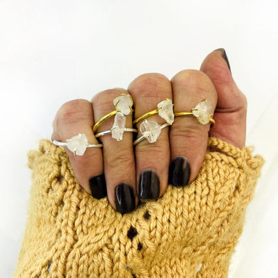 7 crystal quartz rough stone rings shown on a womans hand
