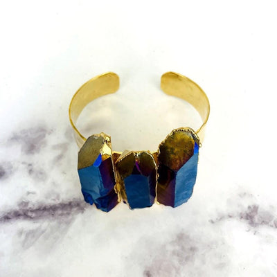 Titanium Crystal Quartz Triple Point Cuff Bracelet with Electroplated 24k Gold on marble background