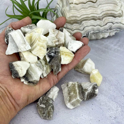 handful of Mexican Onyx Rough Stones in hand for size reference