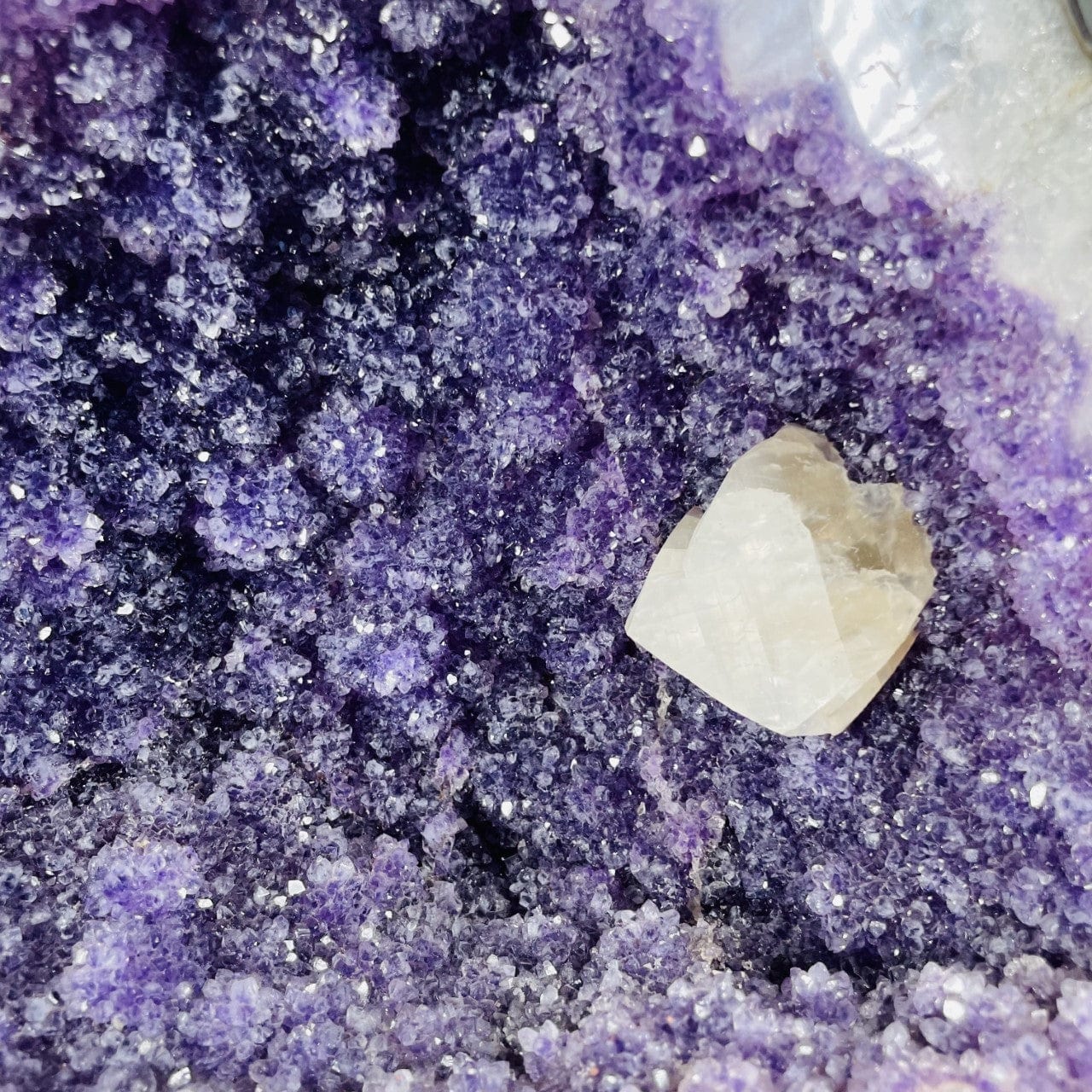 Amethyst Cluster with Calcite Chunk on Metal Stand up close of the crystals